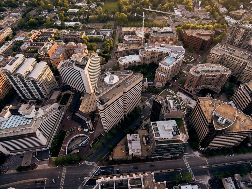Drone view of creative geometric buildings and green areas in residential district of modern city