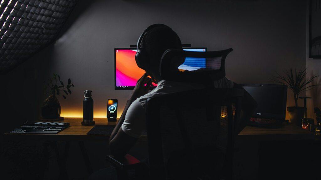 a person wearing headphones sitting in front of a computer